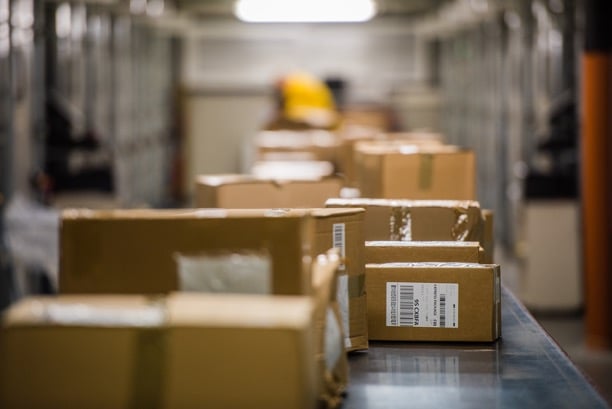Photo of a conveyor belt with cardboard boxes.