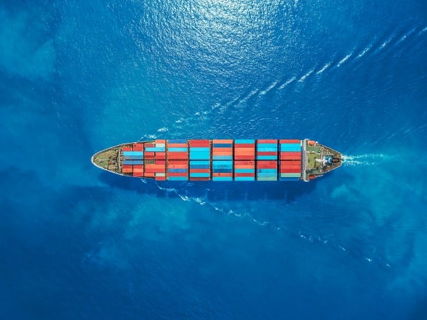 Photo of a cargo ship steadily moving in calm waters.