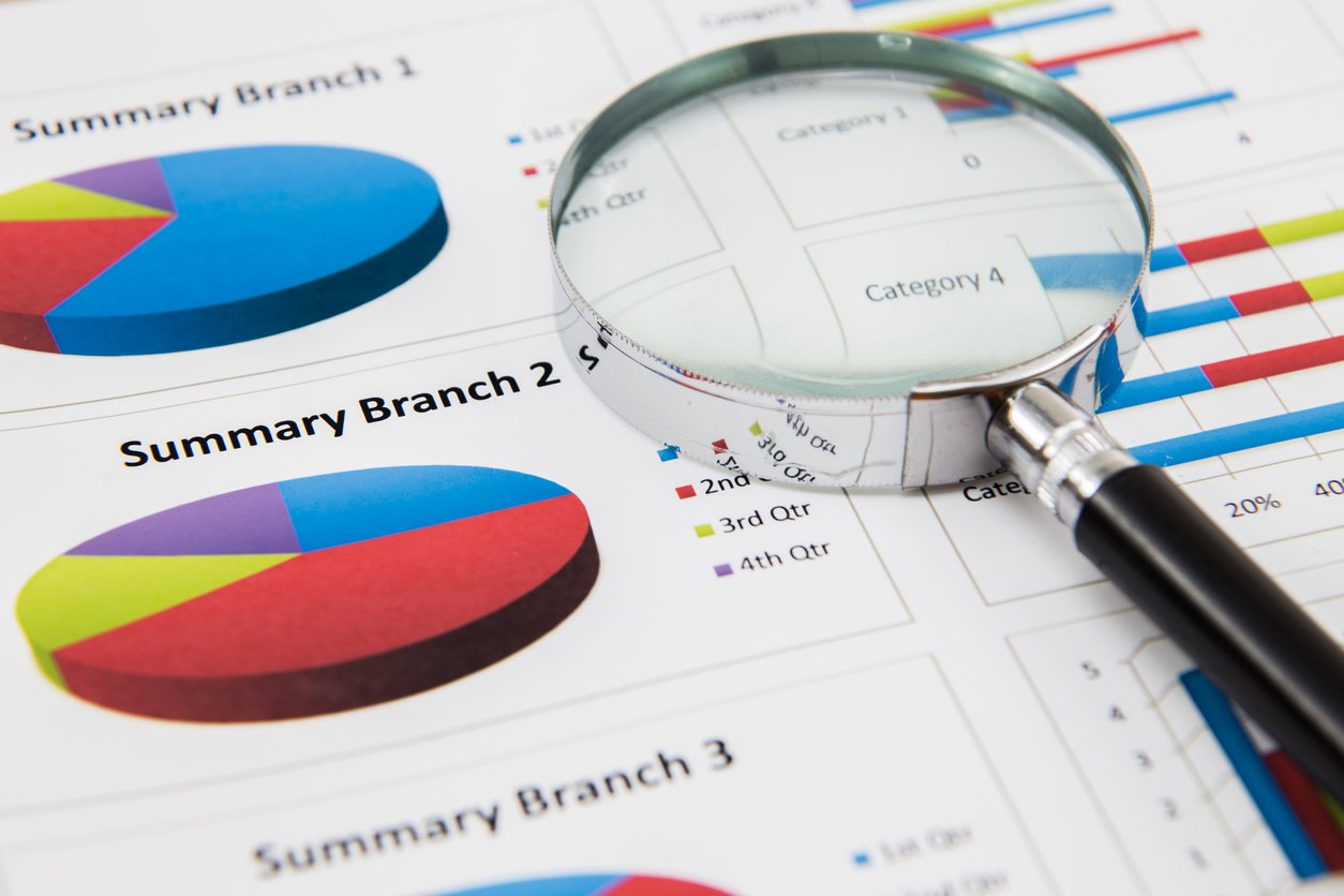 magnifying glass and pen over graph