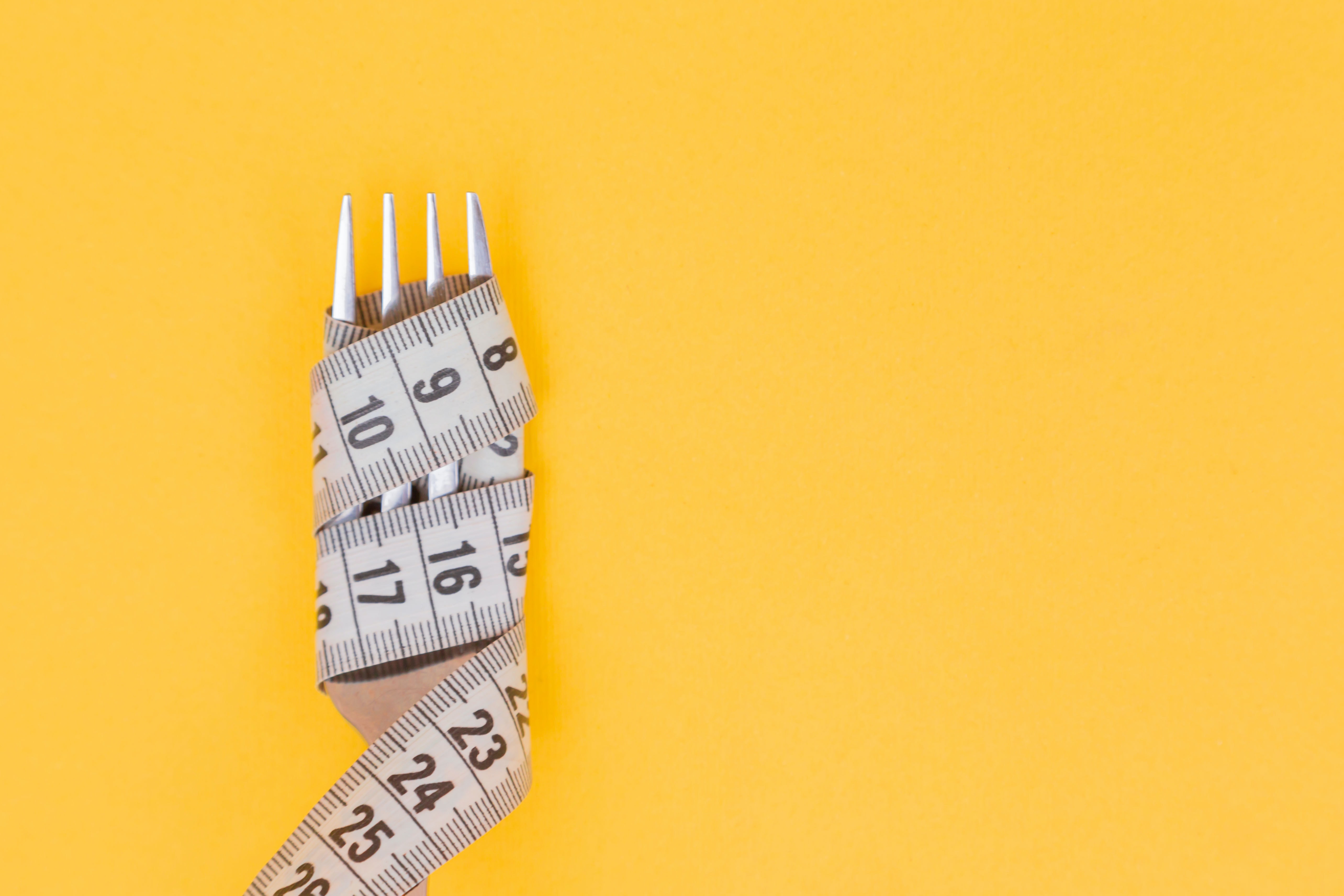 Photo by Diana Polekhina on Unsplash - white and black tape measure on yellow surface