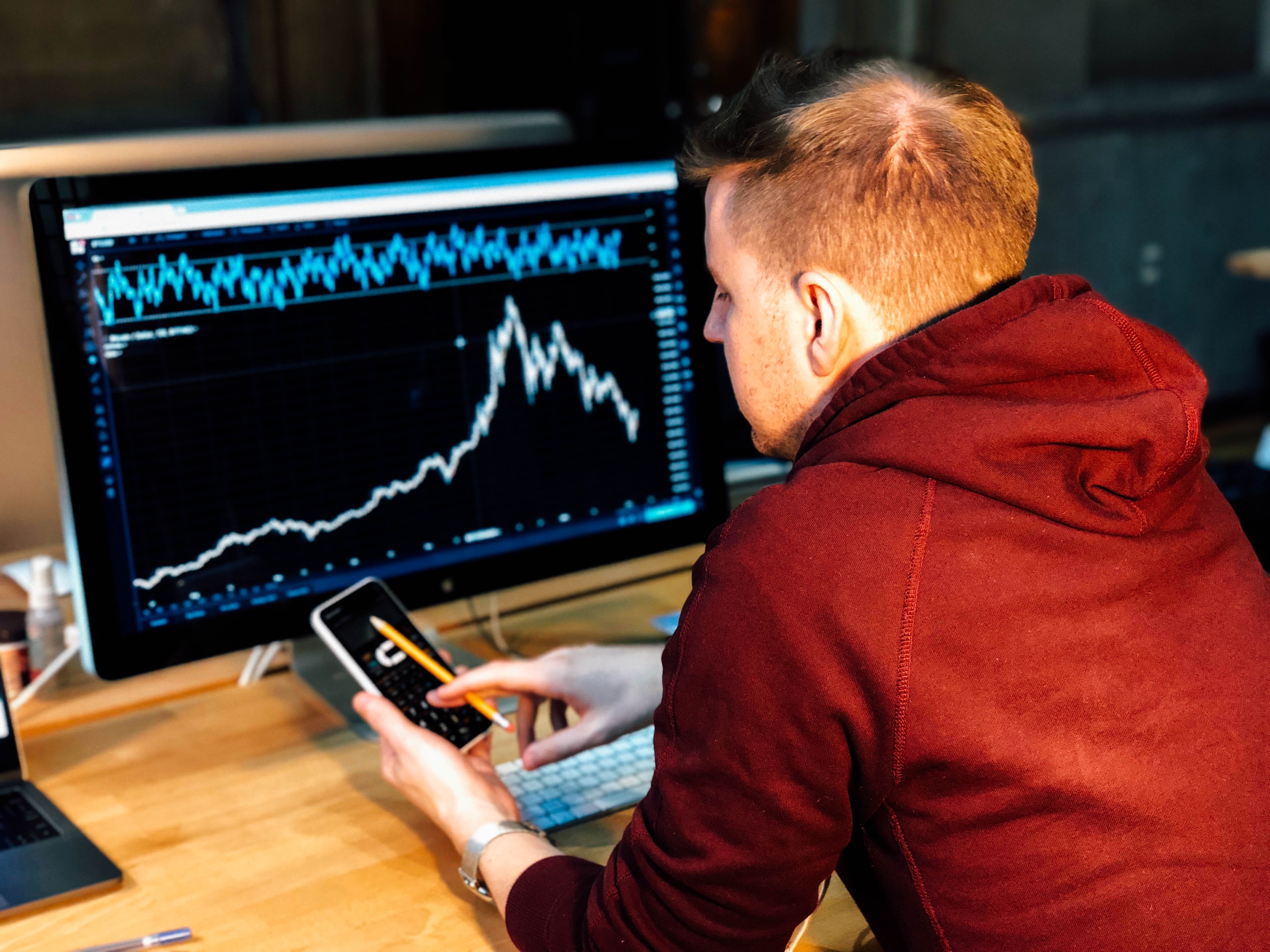 Photo by Chris Liverani on Unsplash - man holding black smartphone with black screen monitor in front