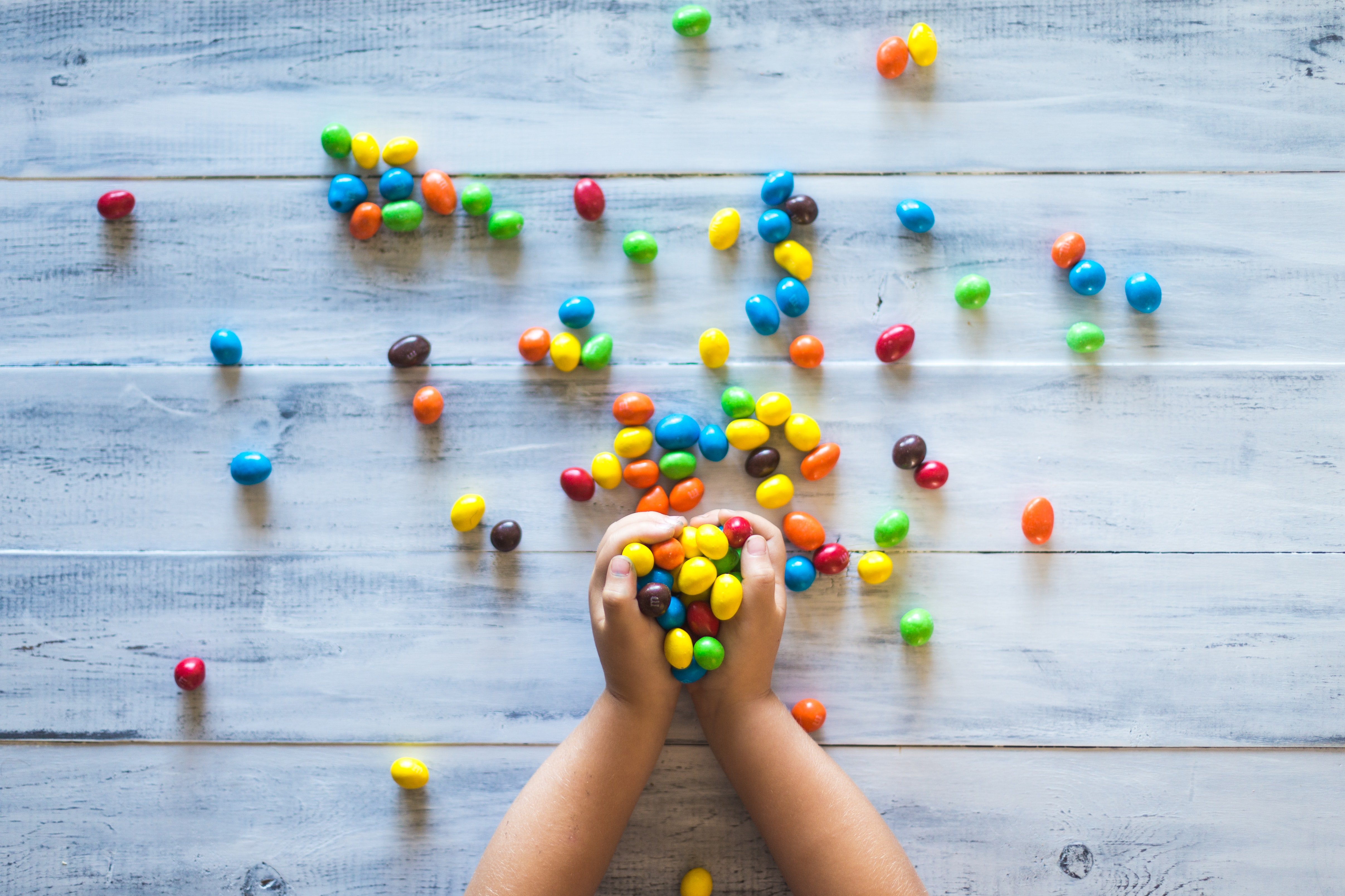 Photo by Patrick Fore on Unsplash - kid holding candies