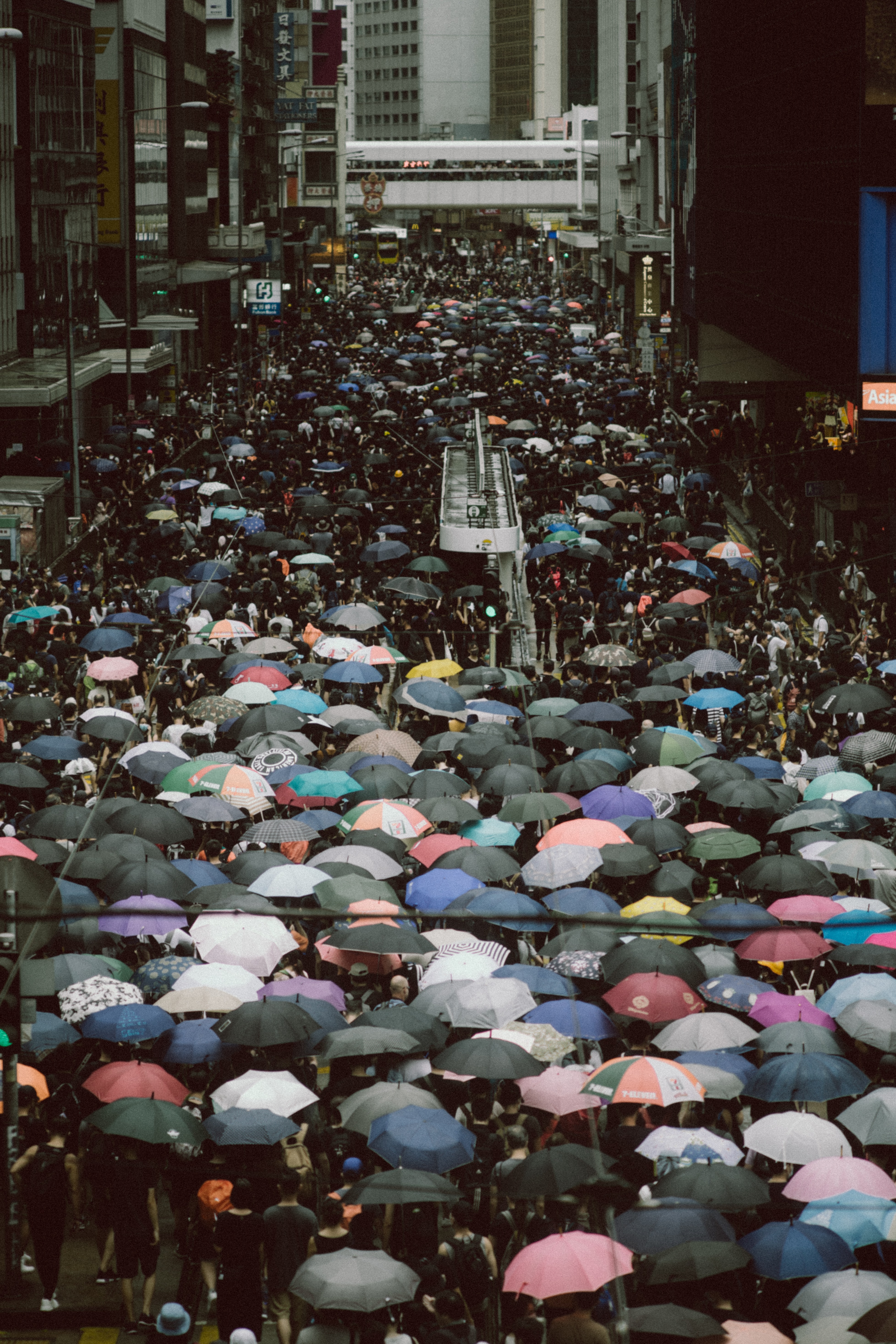 Photo by Joseph Chan on Unsplash - people holding umbrella on road at daytime