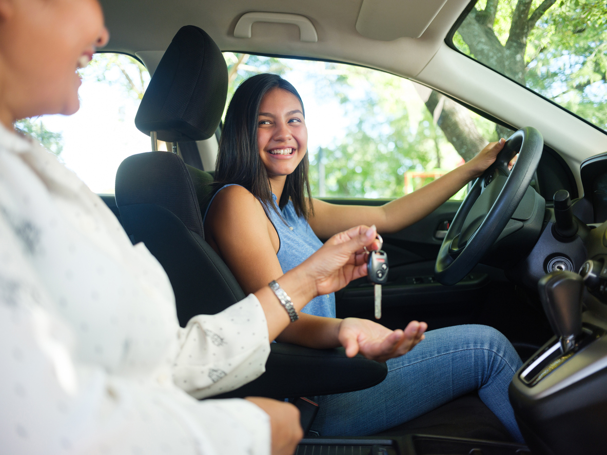 Teenage girl in a car as her mother sits next to her