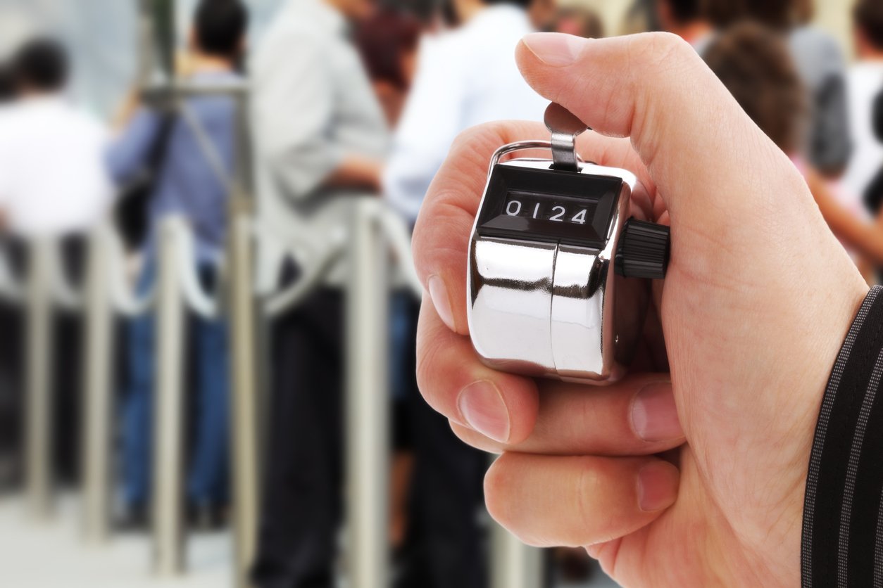 Hand held tally counter counting headcount of people
