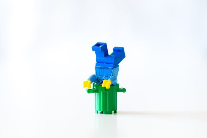 lego cartoon falls into a trash can