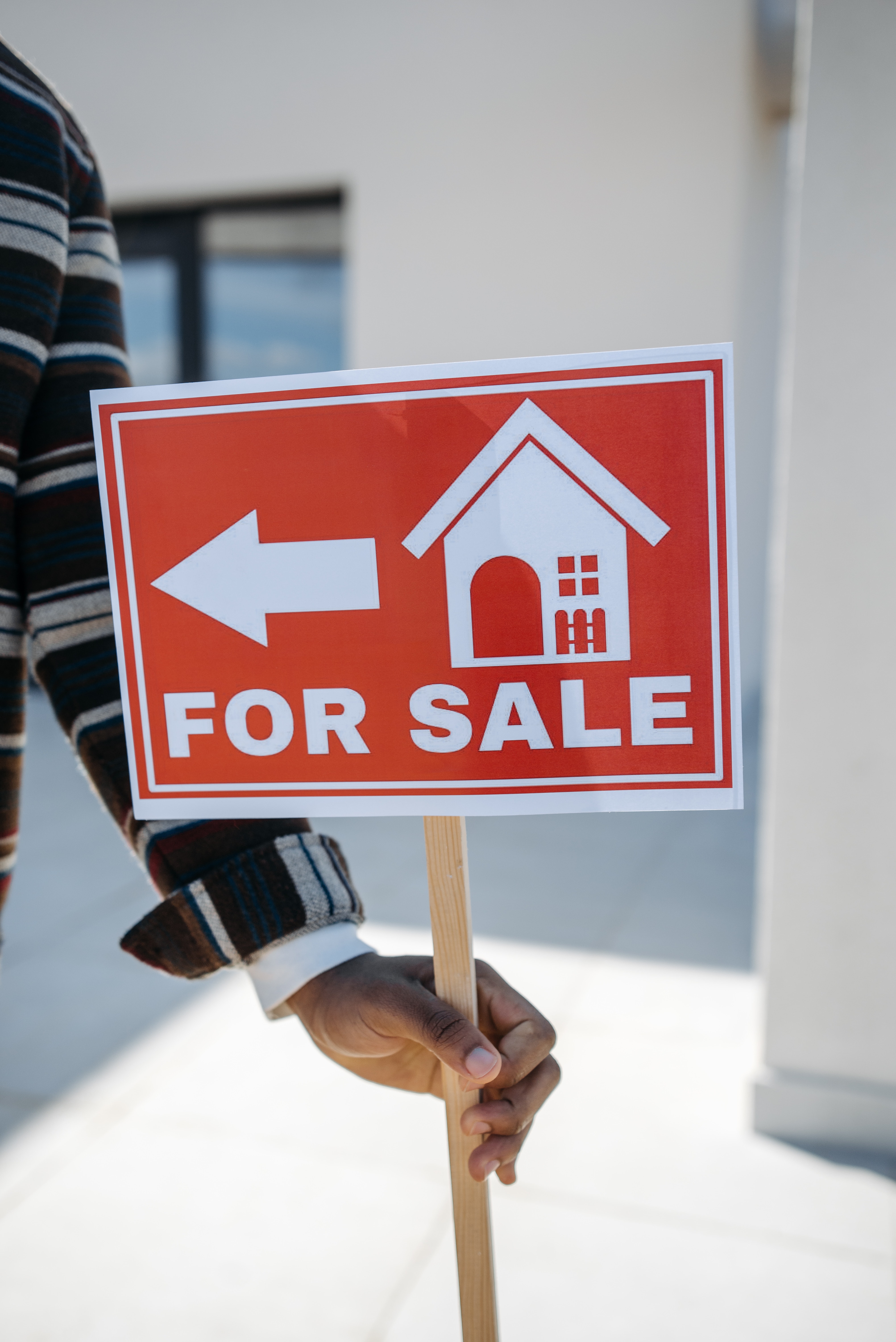 A for sale board in front of a house.