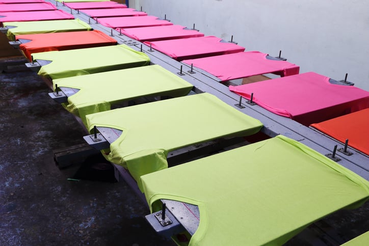 Multiple colored t-shirts prepared for a printing process