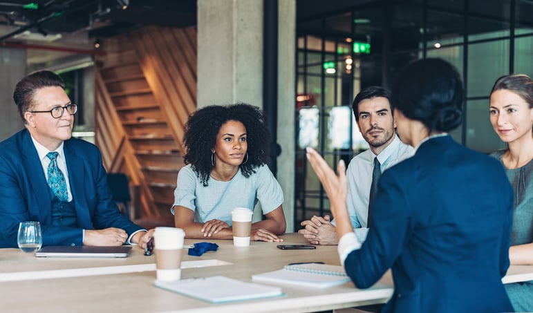 Woman presenting in team meeting of 5