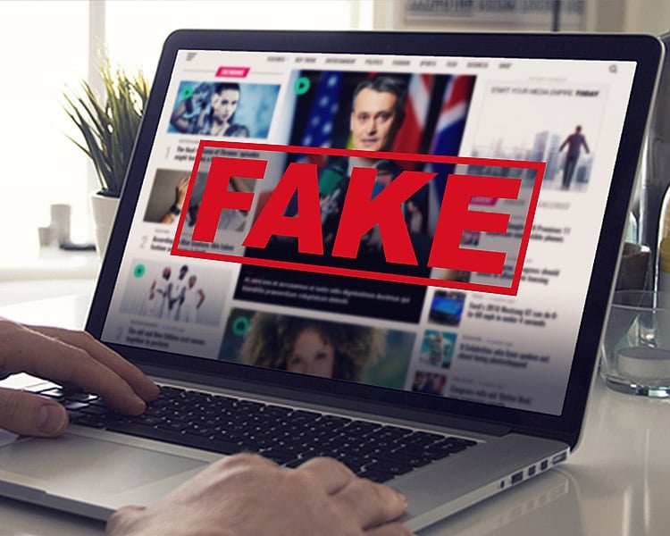 Laptop showing a video with a giant "FAKE" label on it.