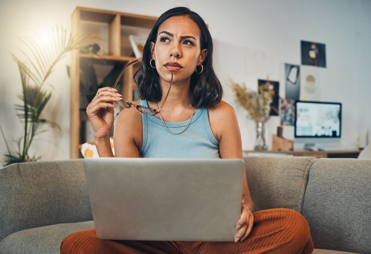Woman sitting with laptop thinking