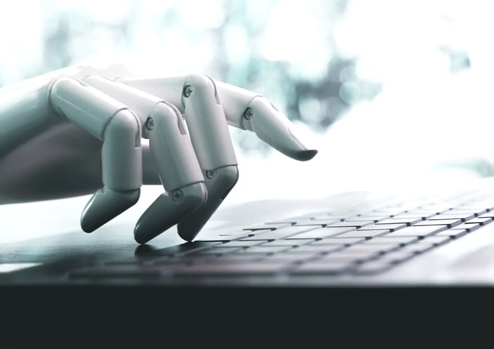 Robot hand typing on a laptop keyboard