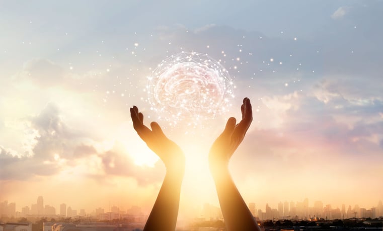 Image of hands held up to the sky, with the sun setting in between, and the image of an artificial intelligence brain depicted