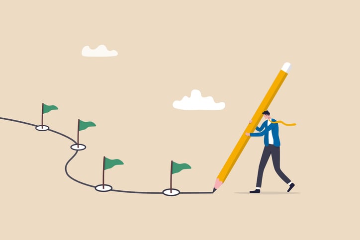 Image of a man holding a giant pencil, drawing a line with different points signposted