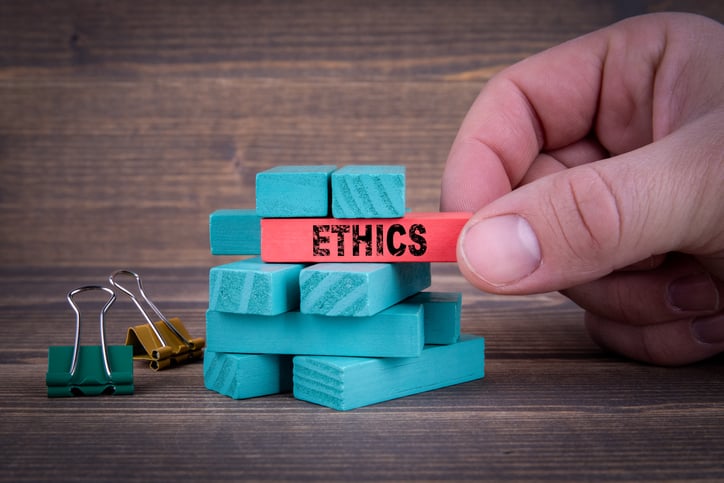 Jenga blocks colored blue, with one block colored red and labelled "ethics"
