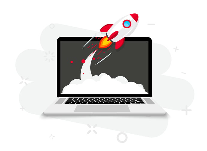 A little rocket launches from a laptop screen.