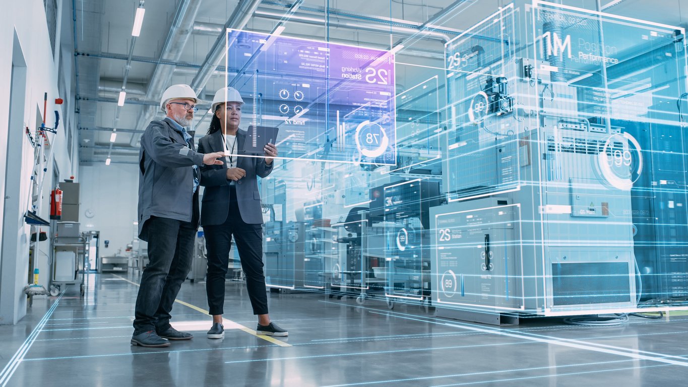 Two workers look at data analyses and visualization in high-tech factory.