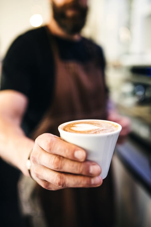 A barista serves a coffee.