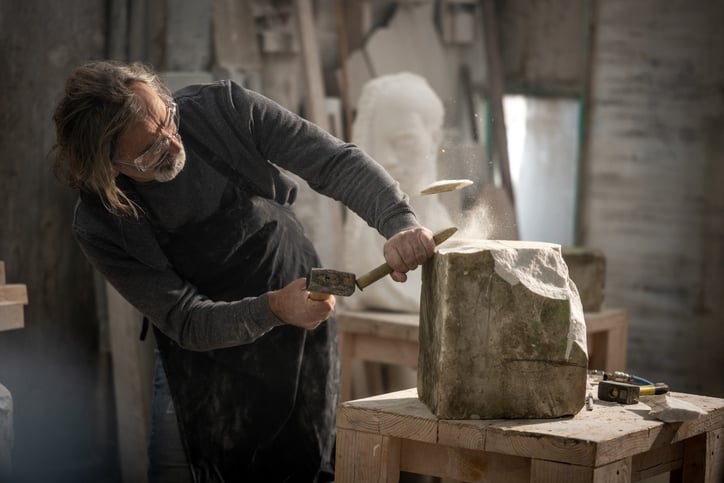 Image of sculptor removing material to create art
