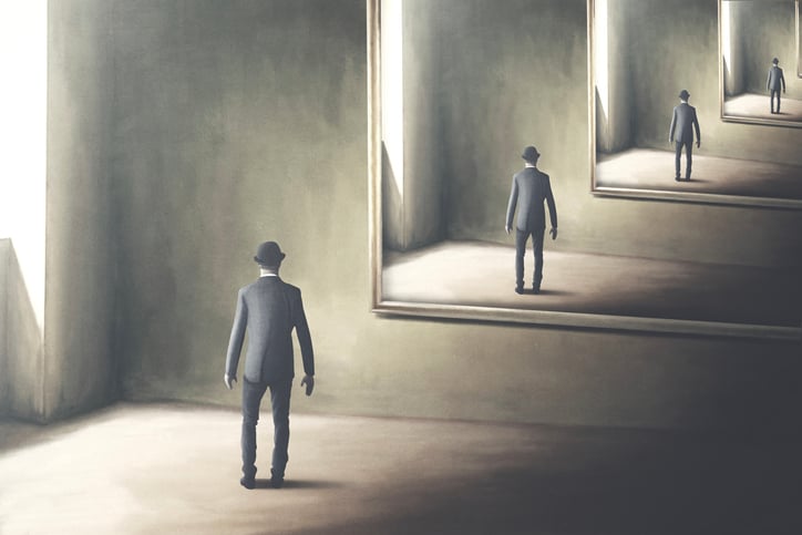 Man looking at reflection, seeing further reflections