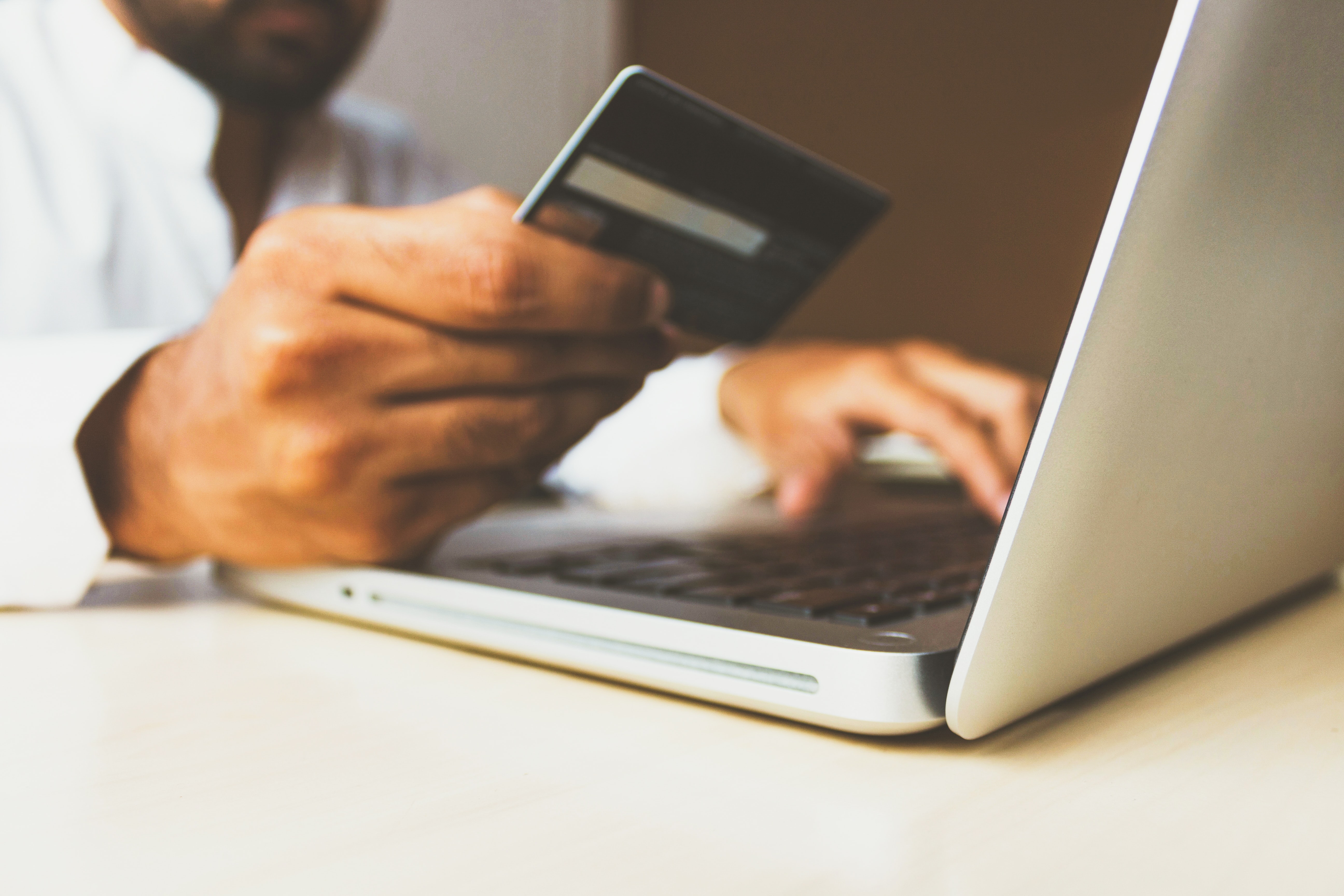 Person using a card and a laptop